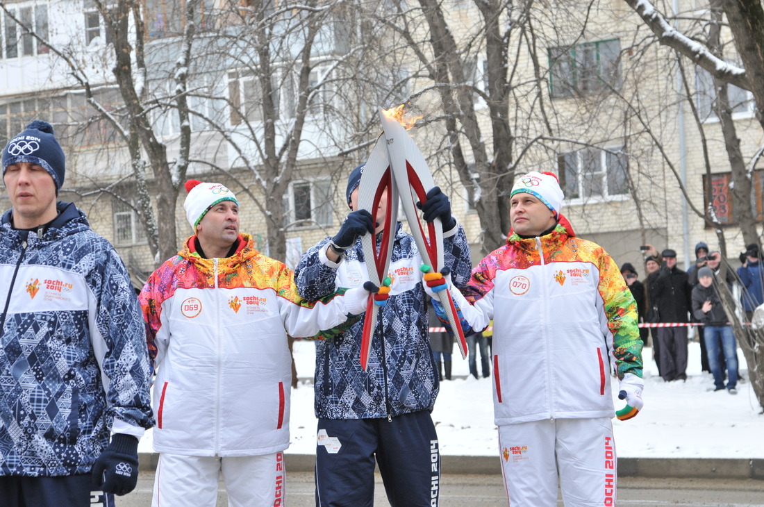 Юрий Берлизев передает факел сочинской Олимпиады следующему факелоносцу