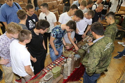 Участники занятий осматривают военные предметы с поисковых экспедиций