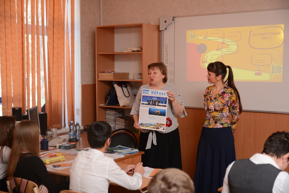Надежда Шевцова (слева) знакомит ребят с корпоративной газетой "Газовый форпост"