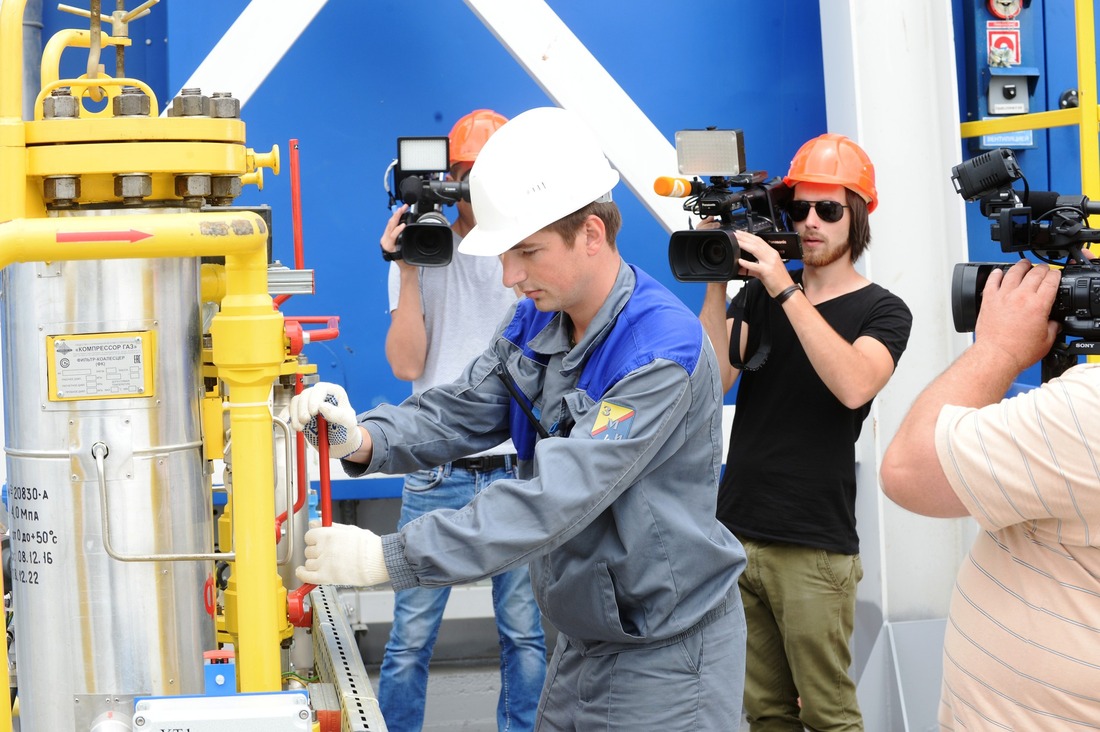 Машинист технологических компрессоров Денис Стахов открывает кран на входе газопровода топливного газа в фильтр блока фильтров топливного газа